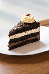Close-up of black forest cake on a white dinner plate, a cut-off cake