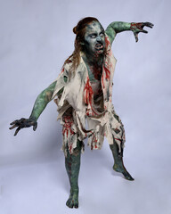 portrait of scary female model wearing spooky halloween costume wearing, ripped clothes and fake...