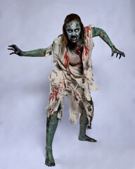 portrait of scary female model wearing spooky halloween costume wearing, ripped clothes and fake...