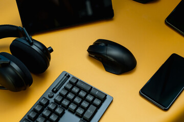 gamer work space concept, top view a gaming gear, mouse, keyboard, joystick, and headset on table background.