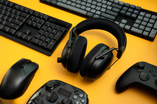 gamer work space concept, top view a gaming gear, mouse, keyboard, joystick, and headset on table background.