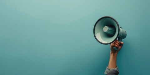 A person holds a megaphone against a blue background, ready to make a statement