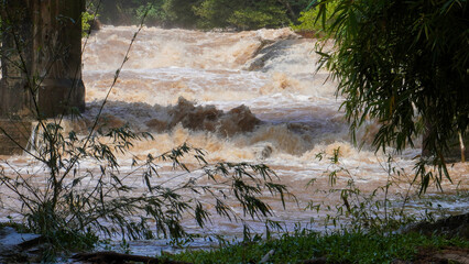 A strong current near a waterfall. Floods flowing in mountain rivers after heavy rains. Flash floods, the effects of global warming and the effects of deforestation.