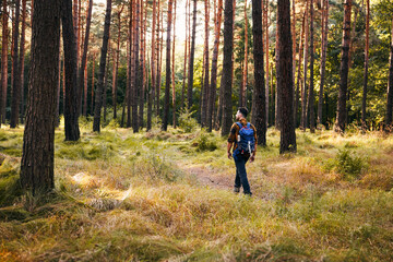 Obraz premium Man hiking through forest during autumn walk looking around