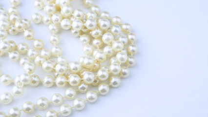 White vintage necklace close-up on a light background, beauty, style, women's jewelry, accessory,...