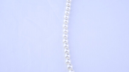 White vintage necklace close-up on a light background, beauty, style, women's jewelry, accessory,...