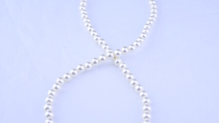 White vintage necklace close-up on a light background, beauty, style, women's jewelry, accessory,...