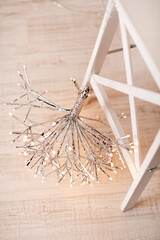 A minimalist star decoration wrapped in twinkling lights, bringing a cozy and modern touch to holiday or home decor. The bright lights give it a magical, festive appeal.