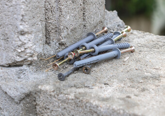 A close-up of the concrete wall with several gray plastic nail tip pushers lying on it
