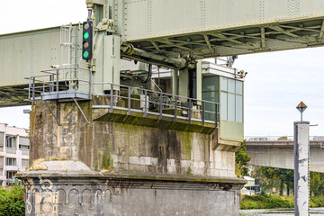 Close-up of base pier of vertical drawbridge at Sint Servaasbrug bridge over river Meuse, operator control cabin, traffic light with green light, Maastricht in South Limburg, Netherlands