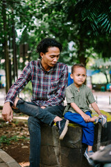 Southeast Asian father chatting with his child, capturing a moment of connection and care