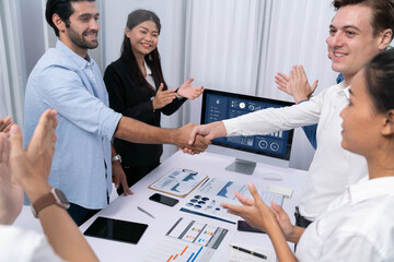 Fototapeta premium Analyst team leader shake hand with his colleague after successful data analysis meeting using FIntech software power with business intelligence or BI dashboard. Prudent