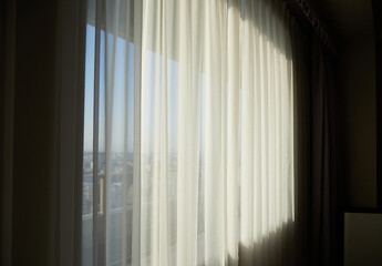 晴天の太陽の日差しとホテルのカーテンの様子