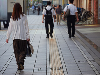 夏の朝の通勤時間で街を歩く人々の姿