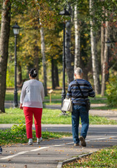 A man and a woman are walking in a park