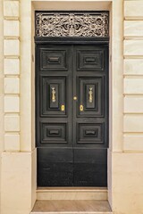 An old wooden black door in a Mediterranean setting in a historic town in Italien.