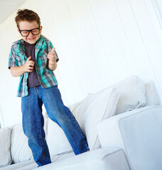 Dance, excited or kid with air guitar on sofa for comedy, humour or funny joke for rock and roll....