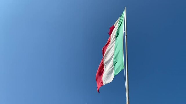 Italian flag vawing in the wind in a windy sumer day. low angle image