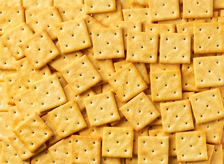 Square crackers background, crispy and crunchy square shape crackers, taken from above, close up.