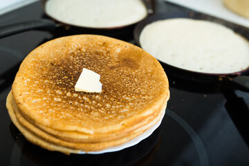 Cooking traditional pancakes from wheat flour in the kitchen