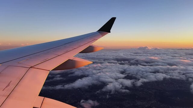 Gros plan sur une aile d'avion avec un coucher de soleil.