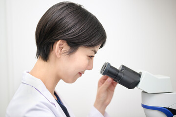 Fototapeta premium 顕微鏡を使う研究職の女性