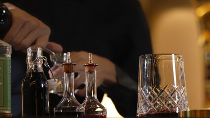 Closeup hand bartender holding jigger to measure liquor sugar into mixing glass ingredients alcohol preparation creative mixed cocktail. Special refresh drink showcasing nightlife mixology. Vinosity.