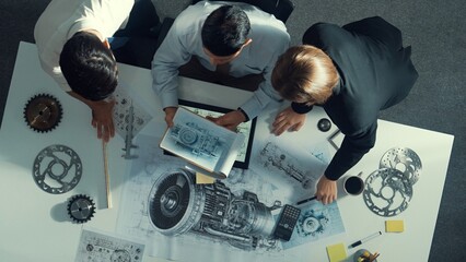 Top down view of skilled engineer working together while looking at jet engine. Aerial view of...
