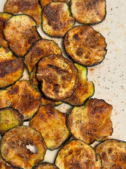 Many round pieces (slices) cooked in a frying pan, savory and heady zucchini (courgette, zucchini) top view. Delicious food.