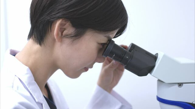 顕微鏡を使う研究職の女性