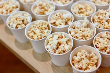 A box of popcorn, neatly contained in a classic paper carton, is ready to be enjoyed. The popcorn is light, fluffy, and perfectly popped, with a golden hue that hints at its delicious buttery flavor.