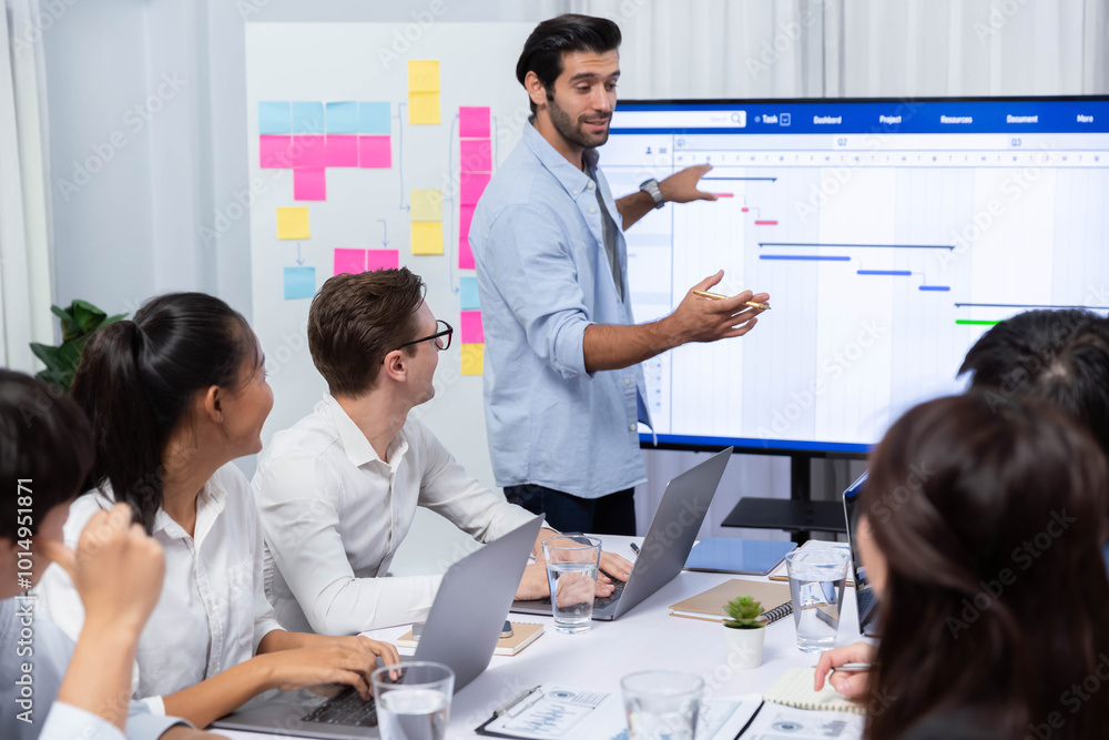Poster Project manager communicate and collaborate with team using project management software display on monitor, tracking progress of project task and making schedule plan at meeting table. Prudent