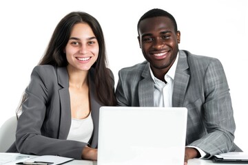 A couple sits together at a table, focused on their laptop