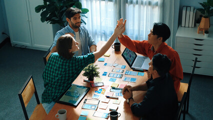Top view of creative team giving high five to celebrate increasing sales or successful idea. Group...