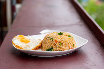 Fried rice with fried egg in white plate.