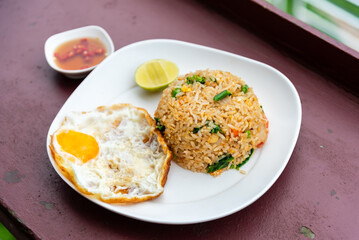 Fried rice with fried egg in white plate.