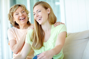 Laugh, mature mother and daughter on sofa with bonding, smile or morning embrace in living room together. Relax, senior mom and girl on couch with happy face for love, care and support in family home