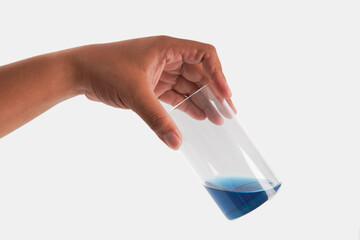 A glass of dark liquid is sitting on a white background
