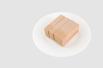 A plate of wafers sits on a white background