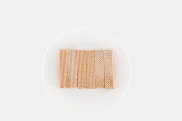 A plate of wafers sits on a white background