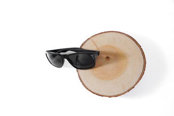 A pair of sunglasses is sitting on a wooden surface