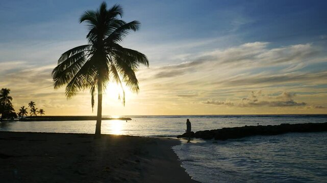 Girl walking on a tropical beach during sunset in shadow light in Guadeloupe