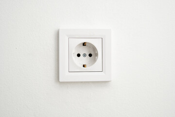 A white european electrical outlet mounted on a white wall