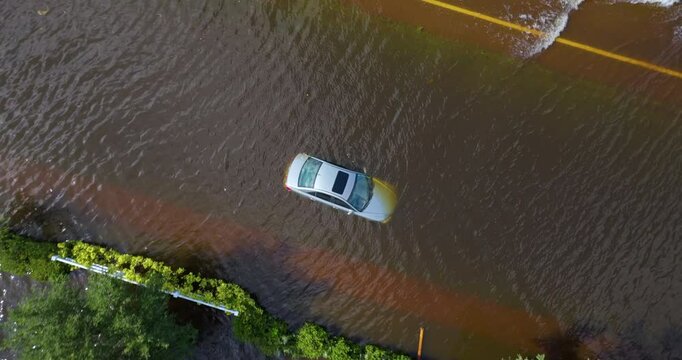 Hurricane flooded car on city street in surrounded with water Florida residential area. Consequences of hurricane Debby natural disaster.