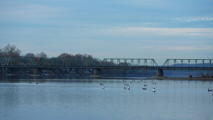 One old iron bridge cross the Delaware river between two old town in autumn