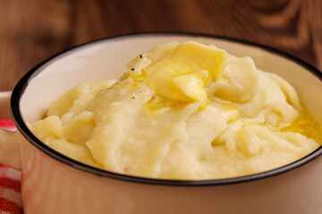 Creamy Mashed Potatoes with Melting Butter Pearl on Dark Wooden Table