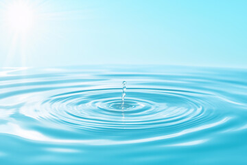 Water droplet creating ripples on a serene blue surface under bright sunlight