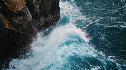 Waves crashing against rocky cliffs in a coastal scene.