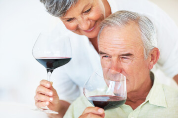 Mature couple, red wine or glasses with alcohol for tasting, celebration or date together at home. Elderly, man and woman with drink or alcoholic beverage for romance, holiday or bonding at house