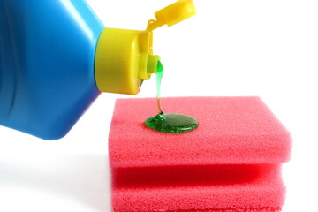 A bottle of dishwashing liquid with a sponge lies on a white background.